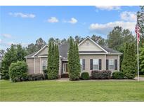 Charming one-story home featuring a well-manicured lawn, a tidy landscape, and a classic design with neutral siding at 45 Remington Hills Dr, Bunnlevel, NC 28323