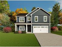 Charming two-story home featuring a two-car garage, manicured lawn, and beautiful landscaping at 68 Mossy Bridge Ct, Lillington, NC 27546