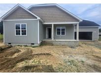 Charming new construction home featuring a covered porch and attached two-car garage at 24 Roll Tide Ct, Angier, NC 27501