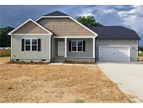 Charming single-story home with light gray siding, stone accents, black shutters, and attached two-car garage at 24 Roll Tide Ct, Angier, NC 27501