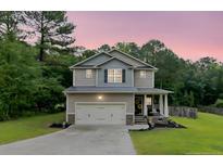 Charming two-story home with a two-car garage, covered porch, and beautifully landscaped front yard at 265 Tactical Dr, Bunnlevel, NC 28323
