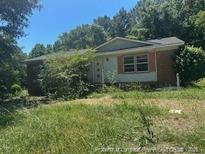 Modest single-story home with brick accents and lush greenery surrounding the property at 5028 Valley View Dr, Sanford, NC 27330
