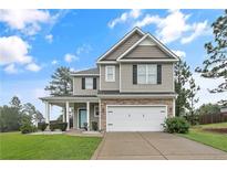 Charming two-story home with a two car garage, stone accents, a covered porch and manicured front lawn at 94 Heatherwood Dr, Lillington, NC 27546
