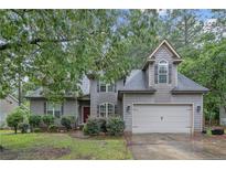 Charming two-story home with gray shingle siding, manicured landscaping, and a two-car attached garage at 98 Pineridge Cv, Sanford, NC 27332