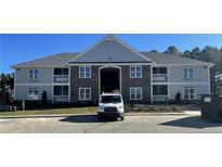 Exterior view of building with gray siding, stone accents, and well-maintained landscaping at 220 Gallery Dr # 201, Spring Lake, NC 28390