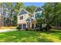 Charming two-story home with a manicured lawn, two-car garage, and a welcoming front porch at 55 High Green Pt, Cameron, NC 28326