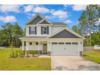 Charming two-story home with a two-car garage, well-manicured lawn, and beautiful curb appeal at 1224 Micro Tower Rd, Lillington, NC 27546