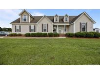 Charming home with manicured lawn, lush shrubbery, and classic design elements for timeless appeal at 140 Bagley Ln, Dunn, NC 28334