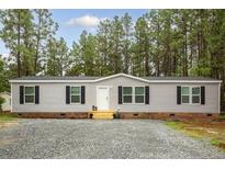 Charming single-story home with gravel driveway and mature trees in a serene setting at 2088 Heritage Way, Cameron, NC 28326