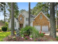 Charming two-story home featuring stone accents, a two-car garage, and professionally landscaped front yard at 256 Barons W Run, Spring Lake, NC 28390