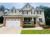 Charming two-story home featuring a stone-accented garage and inviting front porch at 116 Springside Dr, Spring Lake, NC 28390