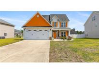 Charming two-story home with orange accents, a two-car garage, and manicured front yard at 152 Century Dr, Cameron, NC 28326