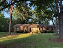 Charming single-story brick home featuring a well-manicured lawn and mature trees, offering a serene setting at 2732 Leaflet Church Rd, Broadway, NC 27505