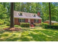 Charming brick home with dormer windows and a well-manicured lawn in a wooded setting at 511 Maplewood Dr, Sanford, NC 27330