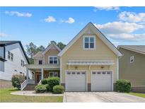 Charming two-story home with a covered porch, two-car garage, and manicured landscaping at 716 Micahs N Way, Spring Lake, NC 28390