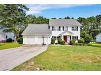 Charming two-story home with a well-manicured front lawn and a two-car garage at 717 Stone Cross Dr, Spring Lake, NC 28390