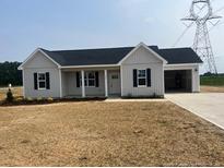 Charming single-story home with light gray siding and a two-car garage on a spacious lot at 1036 Turlington Rd, Dunn, NC 28334