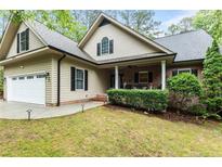 Charming home featuring a two-car garage, covered porch, and well-maintained landscaping at 3046 Creek Run, Sanford, NC 27332