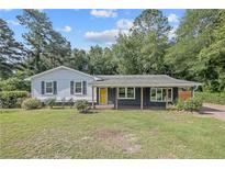 Charming single-story home with a bright yellow front door and covered porch nestled on a well-manicured lawn at 177 Gladiola Dr, Spring Lake, NC 28390