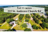 Aerial view of a homesite including two homes, with 5.4 acres, landscaping, and trees at 222 St. Andrews Church Rd, Sanford, NC 27332