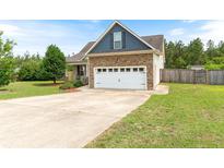 Inviting two-story home with a stone facade, attached two car garage and a well-manicured lawn at 95 Taft Ln, Cameron, NC 28326