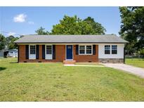 Charming single-story brick home with well-manicured lawn and inviting blue front door at 108 Pine St, Dunn, NC 28334