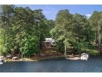 Secluded waterfront home surrounded by mature trees, featuring a private dock and boat at 1363 Maryland Ct, Sanford, NC 27332