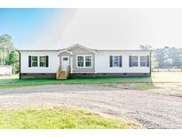 Charming single-story home with a well-maintained lawn and gravel driveway at 3987 Swanns Station Rd, Sanford, NC 27332