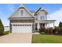 Beautiful two-story home featuring stone accents, a two-car garage, and a well-manicured lawn at 81 Dot Ct, Fuquay Varina, NC 27526