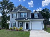 Charming two-story home with gray siding, black shutters, and manicured landscaping at 286 Beacon Hill Rd, Lillington, NC 27546