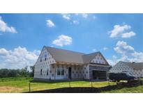 Unfinished new construction home with stone accents and a spacious two-car garage on a sunny day at 70 Camp Rock Rd, Lillington, NC 27546