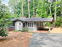 Charming single-story home featuring a carport, beautiful landscaping, and a welcoming brick-paved entrance at 704 Fitts St, Sanford, NC 27330