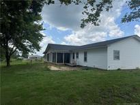 Exterior home view showcasing a spacious backyard and a screened in porch with seating at 71 Marian Ln, Spring Lake, NC 28390