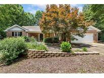 Charming brick home featuring a landscaped front yard with a brick retaining wall and mature trees at 764 Turnbury, Sanford, NC 27332