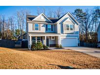 Charming two-story home featuring a covered front porch, attached garage, and neutral siding at 23 Okame Ct, Spring Lake, NC 28390
