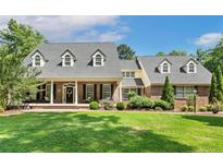 Charming brick home with a columned porch and a manicured front lawn offers classic curb appeal at 2508 Brighton Pt, Sanford, NC 27330