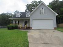 Charming home featuring a large front yard, two-car garage, and inviting covered porch at 2734 Sunnybrook Dr, Sanford, NC 27330