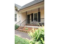 Charming front porch featuring black railings, cream siding, and room for outdoor seating at 2847 Pickard Rd. Rd, Sanford, NC 27330