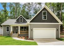 Charming single-Gathering home with a two-car garage, covered porch, and professionally landscaped front yard at 5115 Cardinal Cir, Sanford, NC 27332