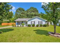 Charming single story home with well maintained lawn, mature trees and a beautifully landscaped front yard at 114 Gum Rd, Dunn, NC 28334