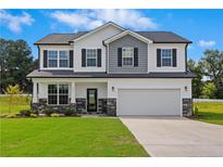 Charming two-story home with a well-manicured lawn, stone accents, and a two-car garage at 55 Fern Ridge Dr, Cameron, NC 28326
