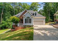 Charming home featuring a manicured lawn, brick accents and an attached two-car garage at 1397 Colorado Trl, Sanford, NC 27332