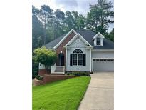 Charming home with a blend of brick and gray siding, complemented by a lush lawn and mature landscaping at 1397 Colorado Trl, Sanford, NC 27332
