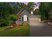 Charming home with lush lawn, brick accents, and two-car garage, nestled among mature trees at 1397 Colorado Trl, Sanford, NC 27332