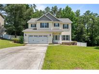 Charming two-story home with a well-manicured lawn and attached two-car garage at 221 Culpepper Rd, Cameron, NC 28326