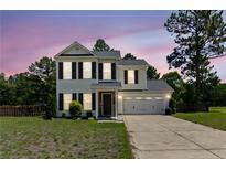 Charming two-story home with a well-manicured lawn and attached two-car garage at 428 Basket Oak Dr, Bunnlevel, NC 28323