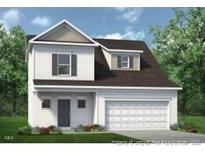 Charming two-story home with a manicured lawn and an attached two-car garage at 73 Pine Vista Way, Sanford, NC 27332