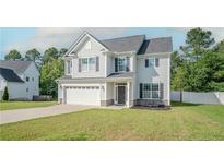 Charming two-story home featuring a two-car garage, well-manicured lawn, and neutral siding at 80 Pedley Pl, Cameron, NC 28326