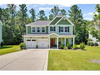 Charming two-story home featuring a two-car garage, lush lawn, and a welcoming front porch at 116 School Side Dr, Spring Lake, NC 28390