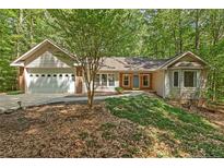 Charming single-story home with a manicured lawn, two-car garage, and lush surrounding trees at 3070 Still Turn, Sanford, NC 27332